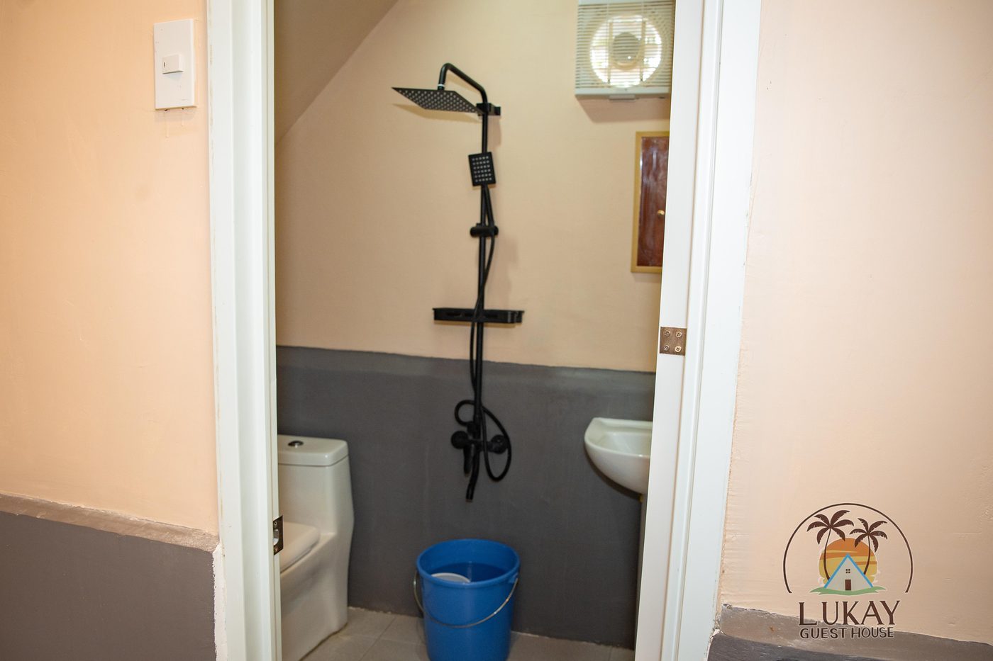 Clean tiled private bathroom with a rain shower