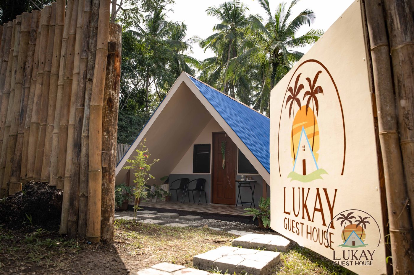 A-frame cabins with the Lukay Guest House sign among the palms