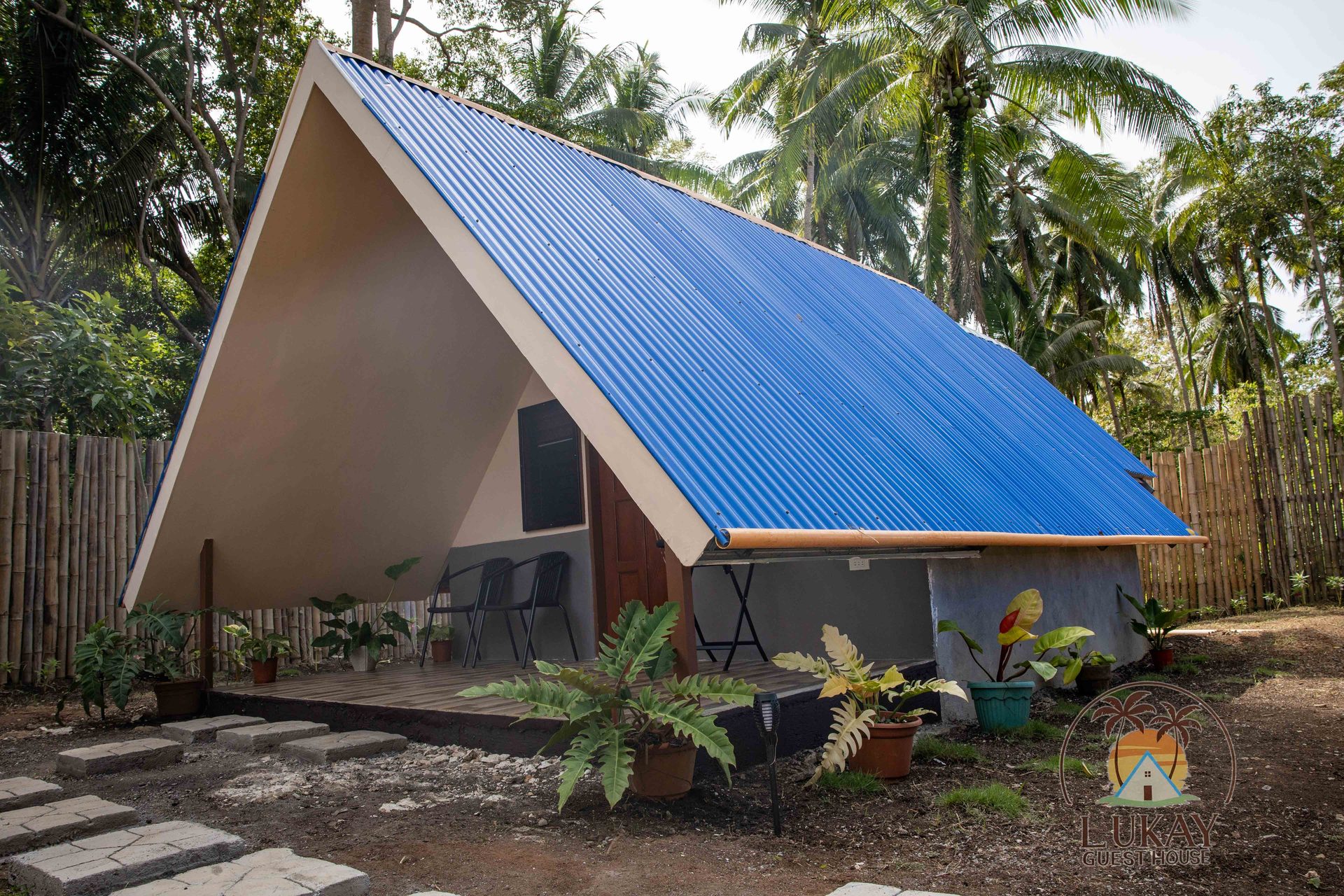 The A-frame cabin with its blue roof, terrace and potted plants